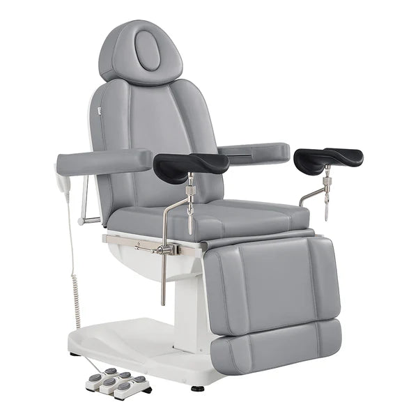 All gray electric medical and esthetician chair featuring adjustable stirrup armrests, extendable leg rests, and a multi-switch foot pedal.