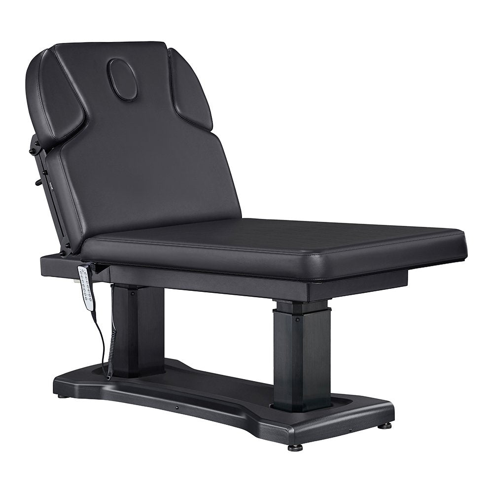 All-black electric facial and medical spa table with an ergonomic contoured cushion, adjustable headrest, wired hand remote, and multi-button foot control pedal.